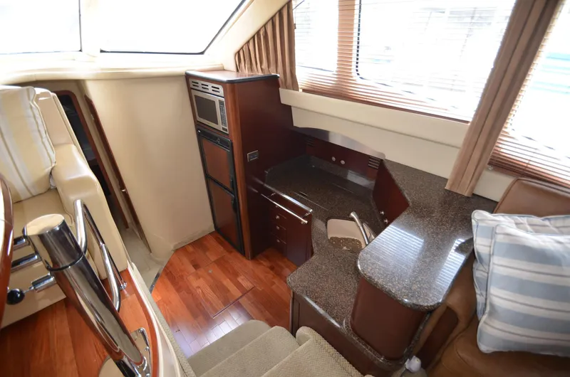 Slide: The Image of Interior of 2005 Sea Ray 420 Sedan Bridge with kitchen and wood flooring. - 8