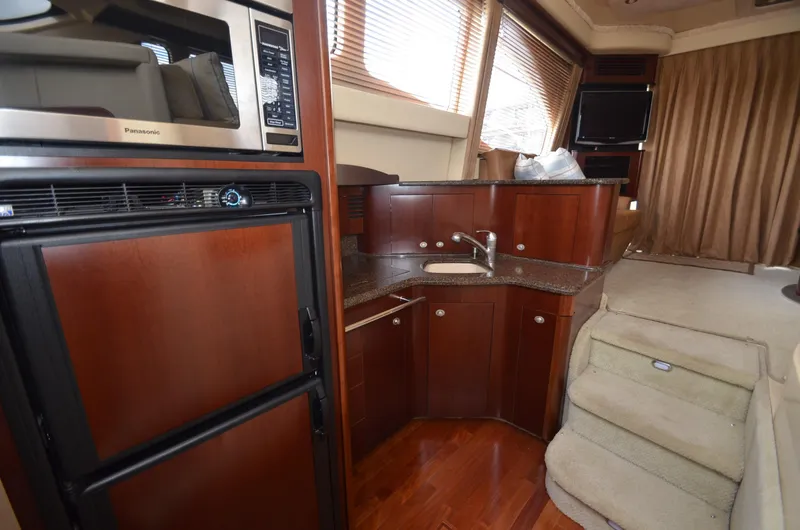 Slide: The Image of Interior of 2005 Sea Ray 420 Sedan Bridge with kitchen and stairs. - 9