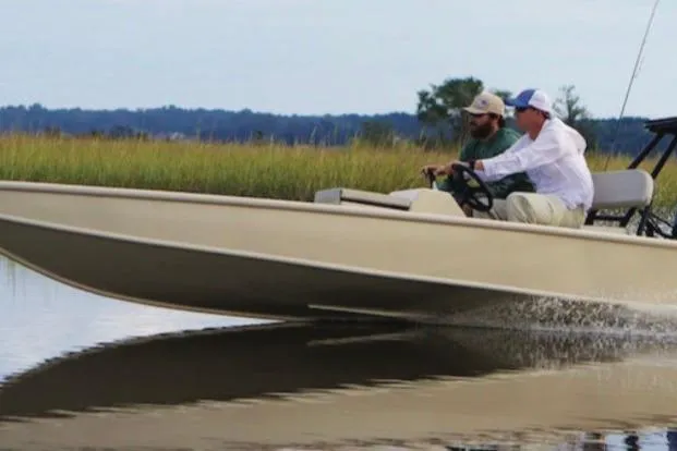 The Image of 2016 Cast and Blast Center Console boat cruising on calm water with two passengers. - 1