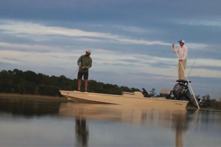 Slide: The Image of Two people fishing on a 2016 Cast and Blast Center Console boat. - 2