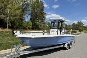 The Image of 2025 Robalo 246 Cayman boat on trailer, parked outdoors under blue sky. - 0
