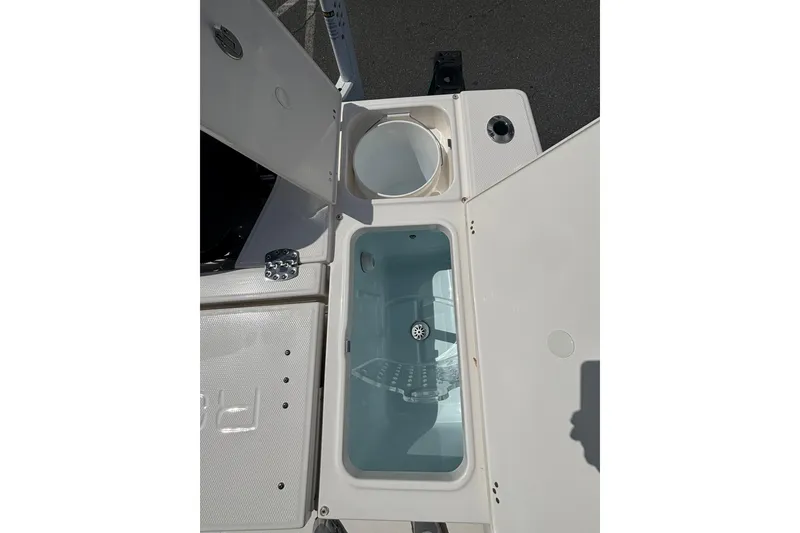 Slide: The Image of Open storage compartments on a 2025 Robalo 246 Cayman boat deck. - 13