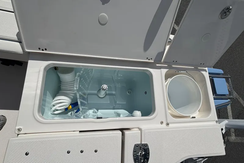 Slide: The Image of 2025 Robalo 246 Cayman boat storage compartments with open lids, showcasing interior features. - 14