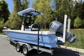 Slide: The Image of 2025 Robalo 246 Cayman boat on trailer, parked outdoors. - 4