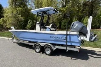 Slide: The Image of 2025 Robalo 246 Cayman boat on trailer, parked outdoors. - 5
