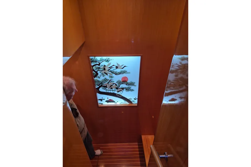 Slide: The Image of Interior of 2006 Altima Flybridge yacht with decorative wall art and wooden staircase. - 14
