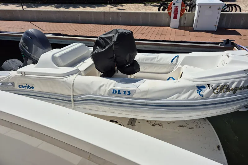 Slide: The Image of White Caribe DL 13 inflatable boat docked, featuring a Yamaha outboard motor. - 19