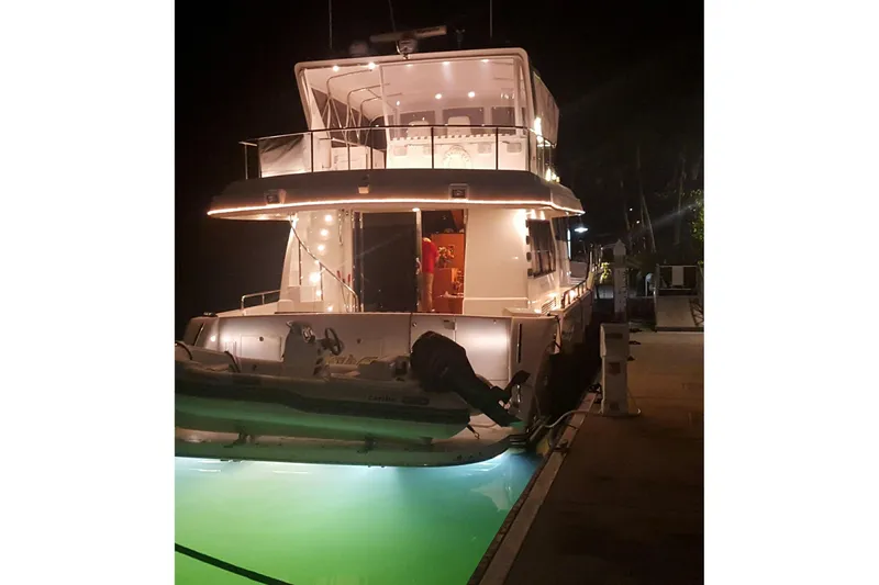 Slide: The Image of Luxurious 2006 Altima Flybridge 76 yacht illuminated at night, docked at a marina. - 4
