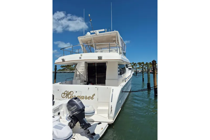 Slide: The Image of Luxurious 2006 Altima Flybridge 76 yacht illuminated at night, docked at a marina. - 6