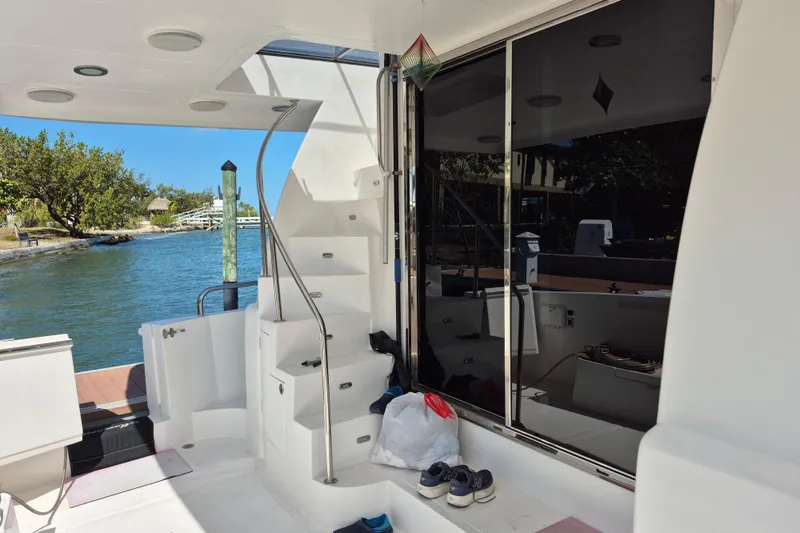 Slide: The Image of 2006 Altima Flybridge yacht interior with stairs, docked by a scenic waterfront. - 7