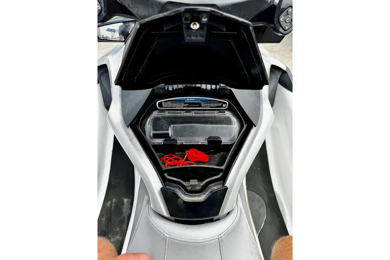Slide: The Image of 2019 Sea-Doo FishPro 155 storage compartment with red safety lanyard and clear container. - 8