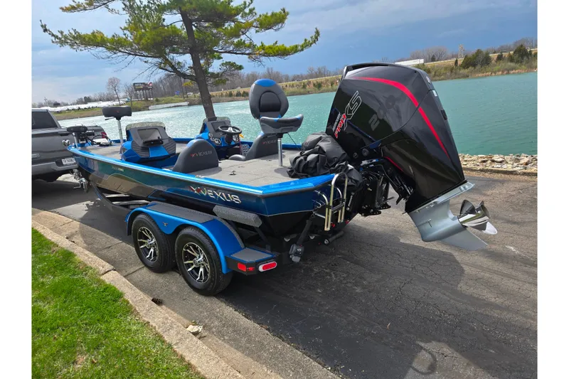 Slide: The Image of 2022 Vexus AVX2080 boat with powerful outboard motor, parked by a scenic lake. - 1