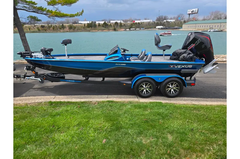 Slide: The Image of 2022 Vexus AVX2080 boat on trailer by a lake, featuring sleek design and modern equipment. - 10