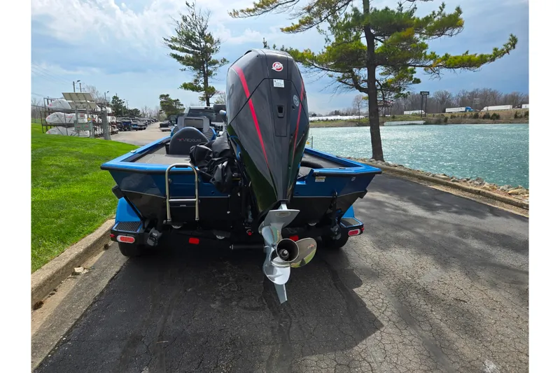 Slide: The Image of 2022 Vexus AVX2080 boat with outboard motor, parked near a scenic lake. - 2
