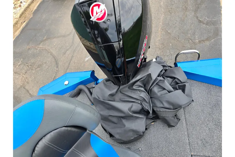 Slide: The Image of 2022 Vexus AVX2080 boat with black motor and blue-accented seating on a paved surface. - 27