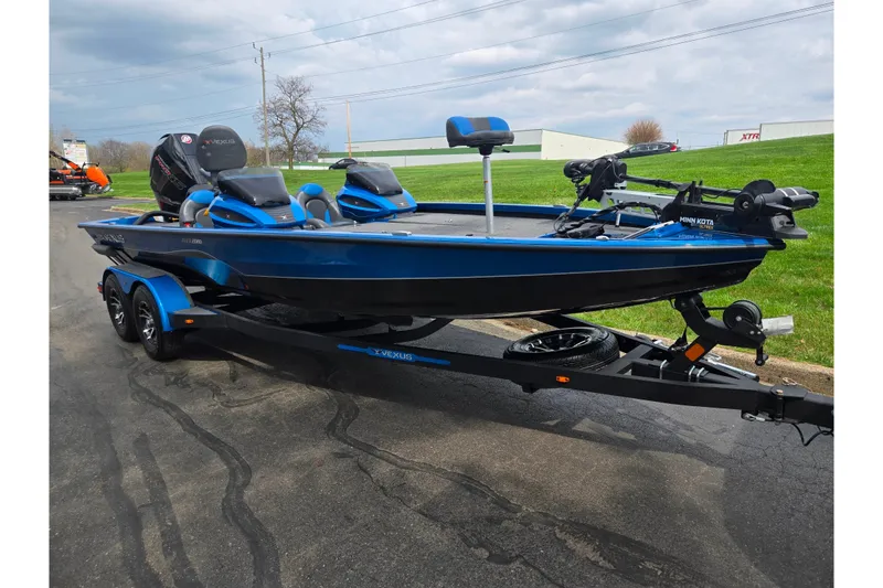 Slide: The Image of 2022 Vexus AVX2080 blue fishing boat on trailer, featuring dual seats and Minn Kota trolling motor. - 5