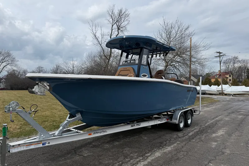 The Image of 2026 Sea Pro 245FLXR Sandbar boat on trailer, parked outdoors on a cloudy day. - 1