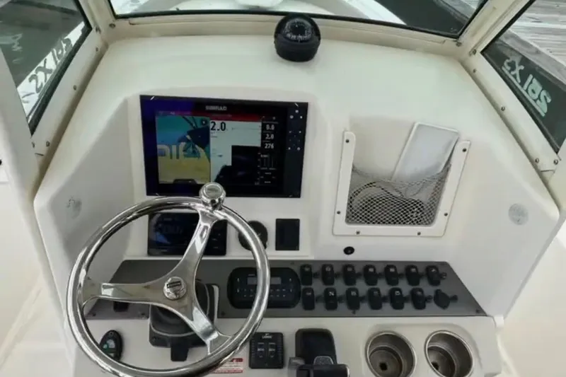Slide: The Image of 2013 Scout 251 XS boat dashboard with steering wheel and control panel. - 3