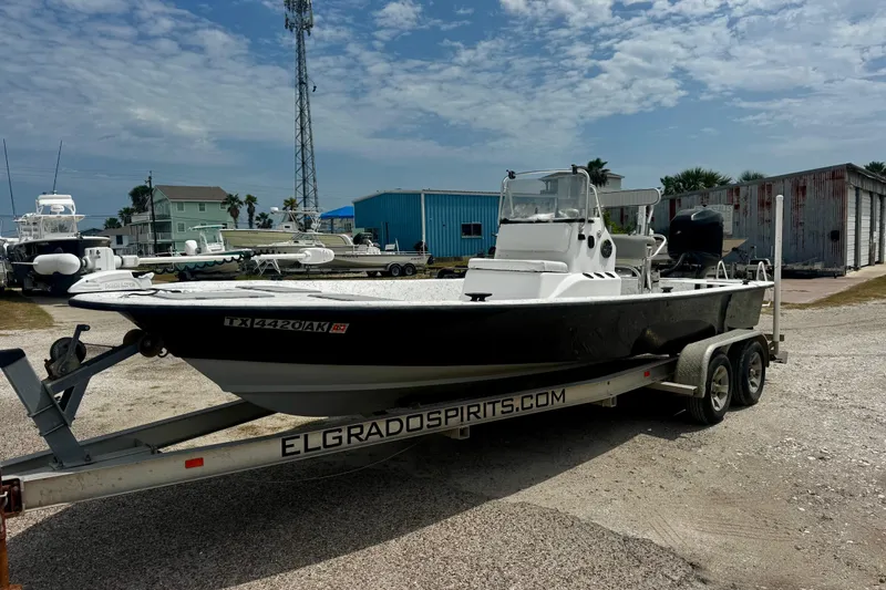 The Image of 2007 Haynie 23 Bigfoot boat on trailer in marina setting under cloudy sky. - 0