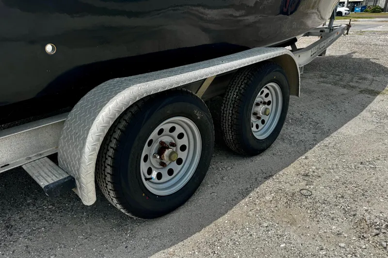 Slide: The Image of Trailer wheels of a 2007 Haynie 23 Bigfoot boat on gravel surface. - 28