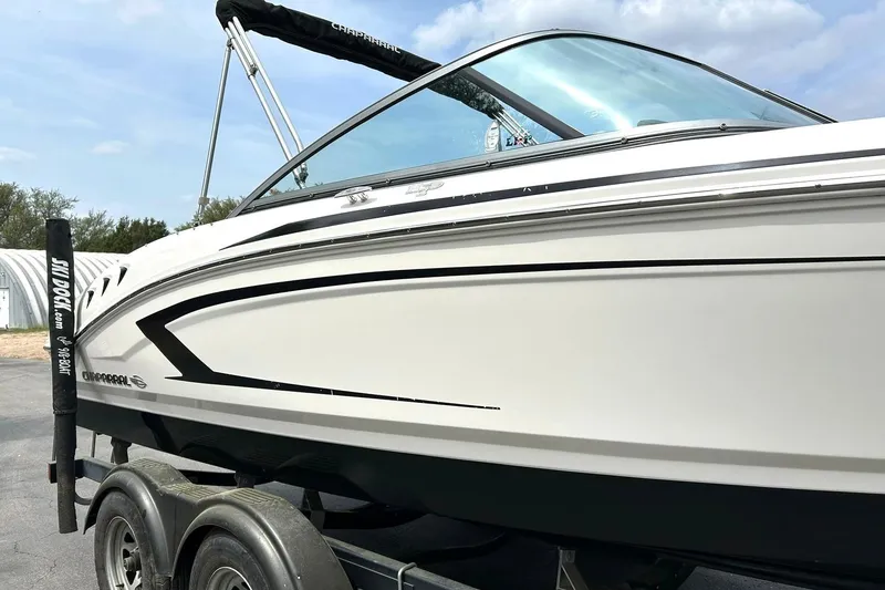 Slide: The Image of 2016 Chaparral 21 H2O Sport boat on trailer, sleek white design, outdoor setting. - 12