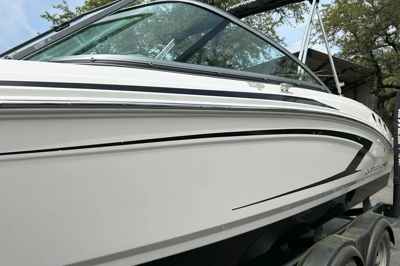 Slide: The Image of 2016 Chaparral 21 H2O Sport boat, sleek white exterior with black accents, on trailer. - 18