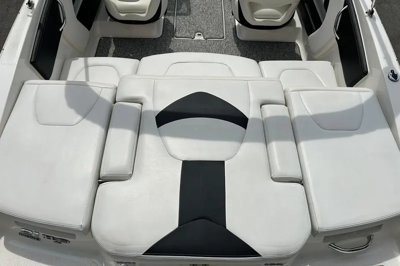 Slide: The Image of 2016 Chaparral 21 H2O Sport boat interior with white and black cushioned seating. - 25