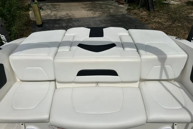 Slide: The Image of 2016 Chaparral 21 H2O Sport boat with white cushioned seating and black accents. - 26