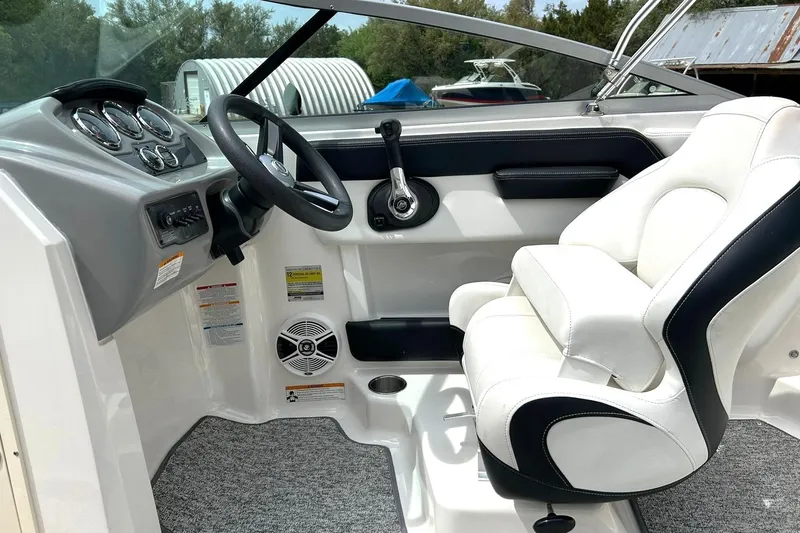 Slide: The Image of 2016 Chaparral 21 H2O Sport boat interior with steering wheel and white captain's seat. - 3