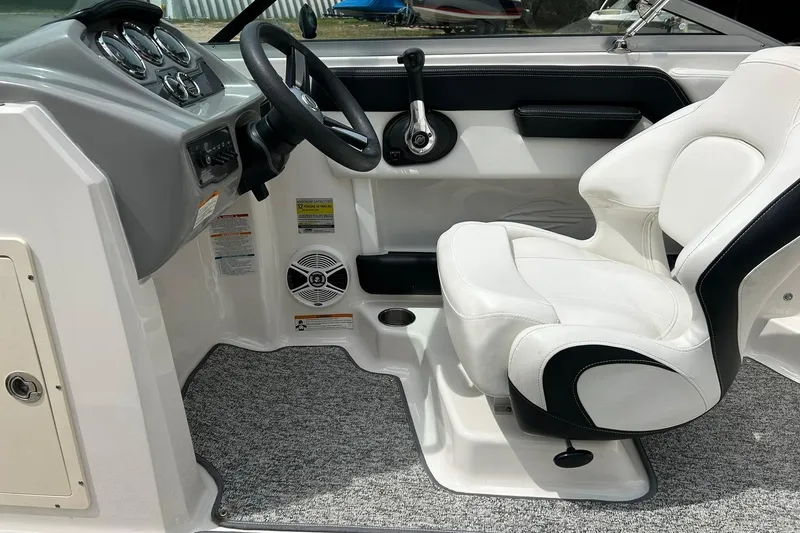 Slide: The Image of 2016 Chaparral 21 H2O Sport boat interior with steering wheel and white captain's seat. - 35