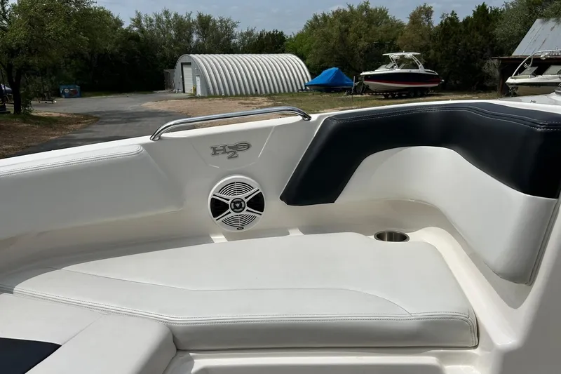Slide: The Image of 2016 Chaparral 21 H2O Sport boat interior with cushioned seating and speaker. - 45