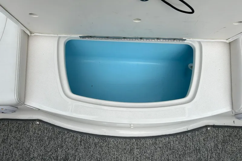 Slide: The Image of Open storage compartment in 2016 Chaparral 21 H2O Sport boat, featuring blue interior. - 51