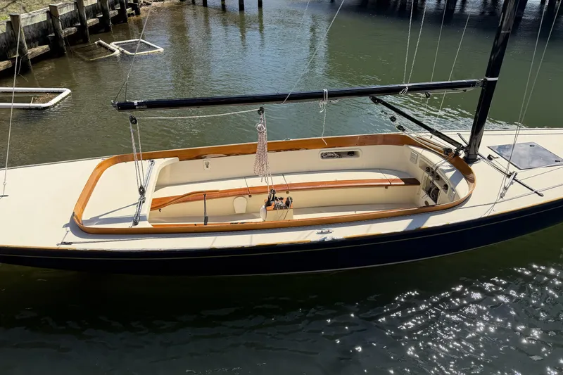 Slide: The Image of 2014 C.W. Hood 32 Daysailer on calm water, showcasing sleek design and wooden accents. - 14