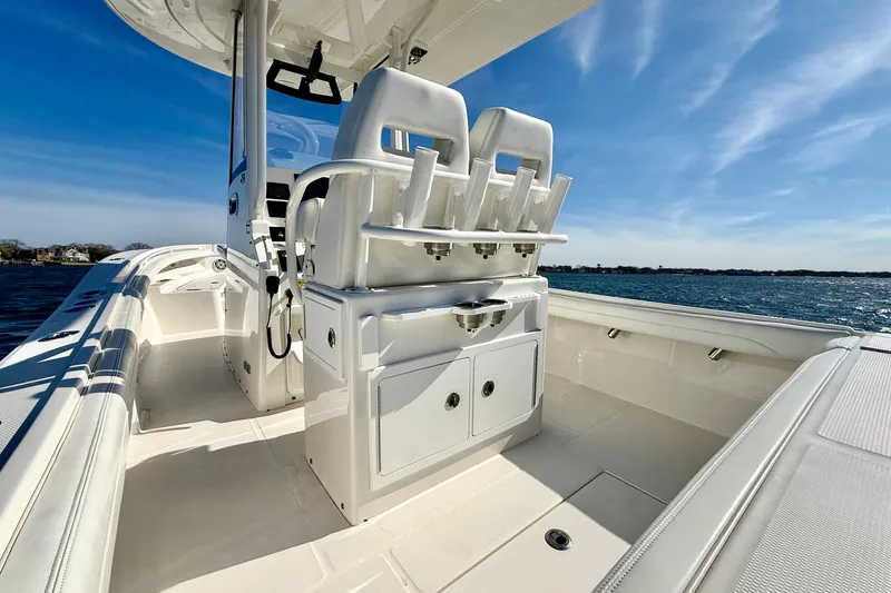 Slide: The Image of 2022 Regulator 23 boat interior with seating and storage, under a clear blue sky. - 11