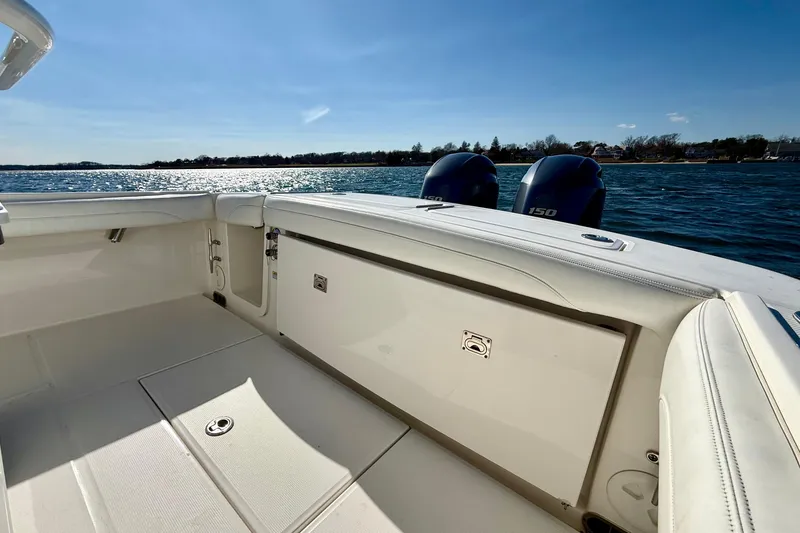 Slide: The Image of 2022 Regulator 23 boat interior with dual outboard motors on a sunny day. - 12