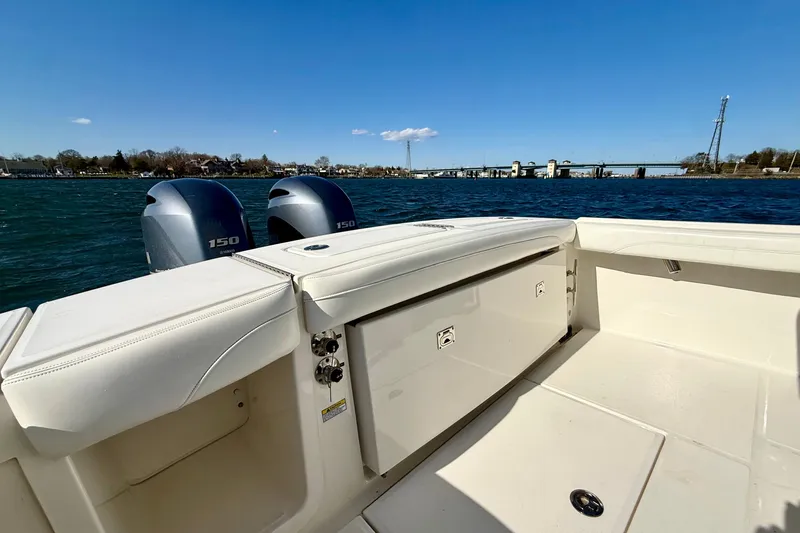 Slide: The Image of 2022 Regulator 23 boat with twin 150 engines on a sunny day by the water. - 13