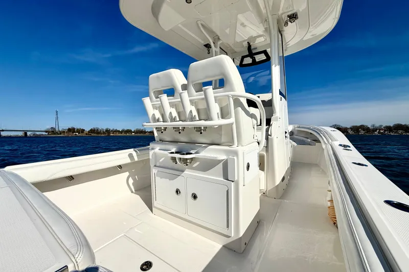 Slide: The Image of 2022 Regulator 23 boat interior with seating and storage, cruising on a sunny day. - 9