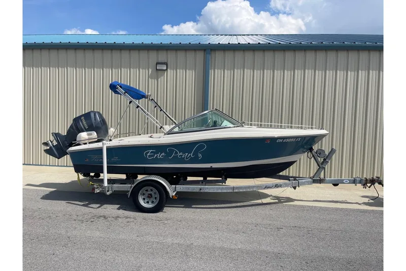 Slide: The Image of 2013 Pioneer 175 Venture boat on trailer, parked outside a metal building. - 1