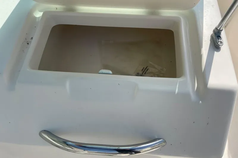 Slide: The Image of Open storage compartment on a 2013 Pioneer 175 Venture boat, featuring a chrome handle. - 24