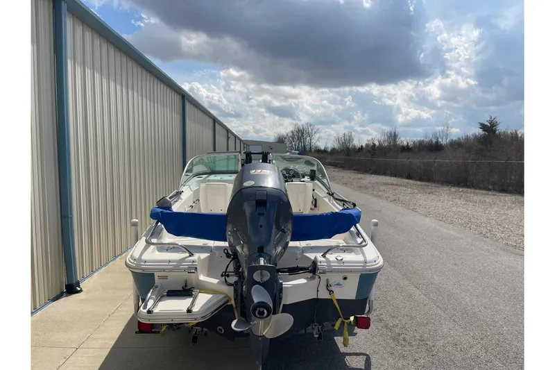 Slide: The Image of 2013 Pioneer 175 Venture boat with outboard motor, parked beside a metal building under cloudy skies. - 5