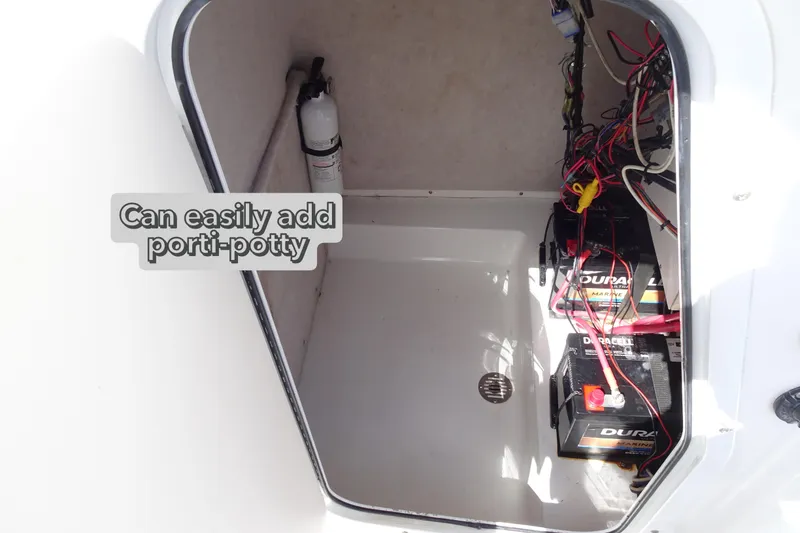 Slide: The Image of 2005 Sea Pro 206 Center Console storage area with batteries and fire extinguisher. - 15