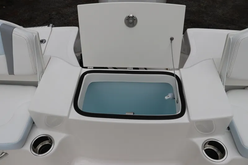 Slide: The Image of 2026 Robalo R180 Center Console boat with open storage compartment and cup holders. - 13