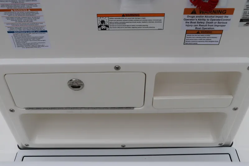 Slide: The Image of 2026 Robalo R180 Center Console storage compartment with safety warnings and checklist. - 26