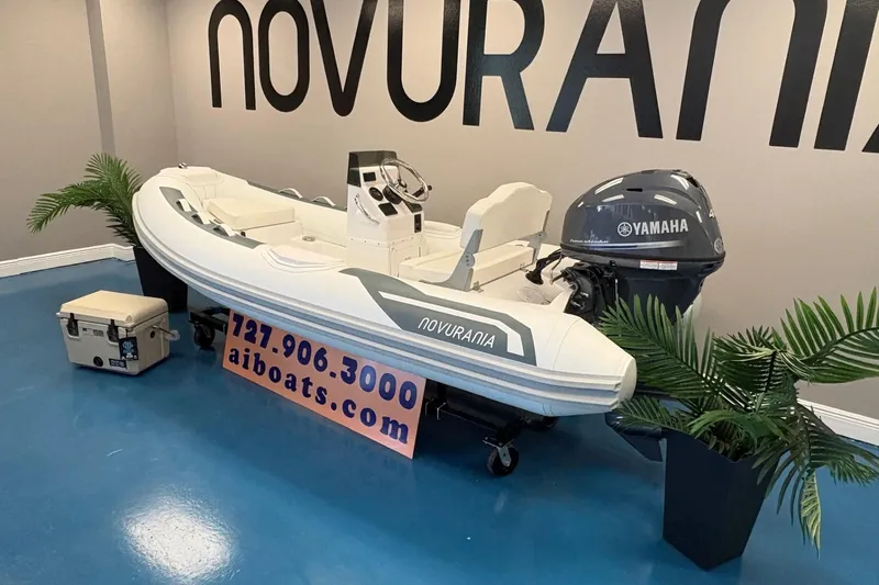 Slide: The Image of 2026 Novurania DL 360 boat with Yamaha engine displayed indoors, surrounded by plants. - 2