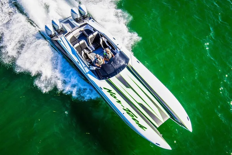 Slide: The Image of 2027 Nor-Tech 4000 Roadster speedboat cruising on vibrant green water. - 12