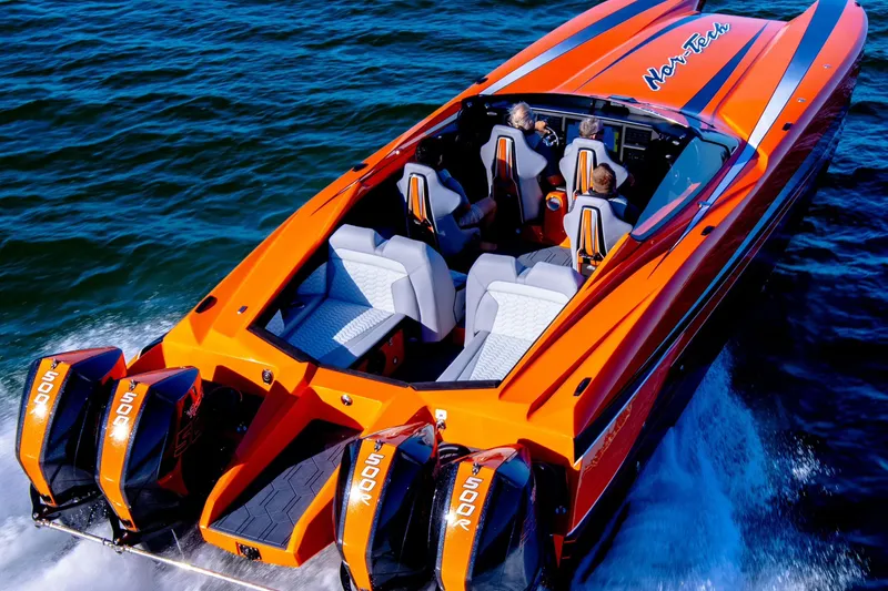 Slide: The Image of 2027 Nor-Tech 4000 Roadster in vibrant orange, cruising on water with powerful engines. - 3
