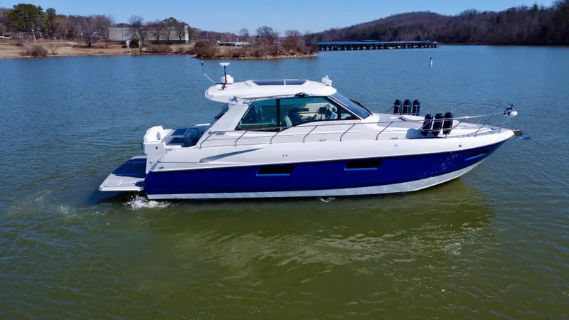 The Image of 2012 Cruisers Yachts 48 Cantius on a serene lake with scenic background. - 1