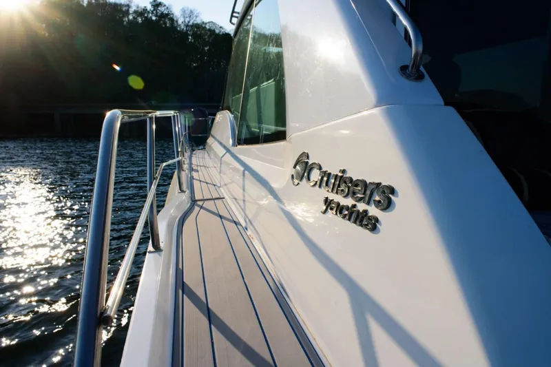 Slide: The Image of 2012 Cruisers Yachts 48 Cantius on water, sunlit deck, brand logo visible. - 10