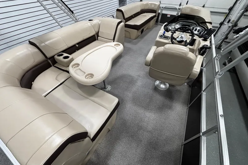 Slide: The Image of 2018 Sun Tracker Party Barge 20 DLX interior with beige seating and steering console. - 17