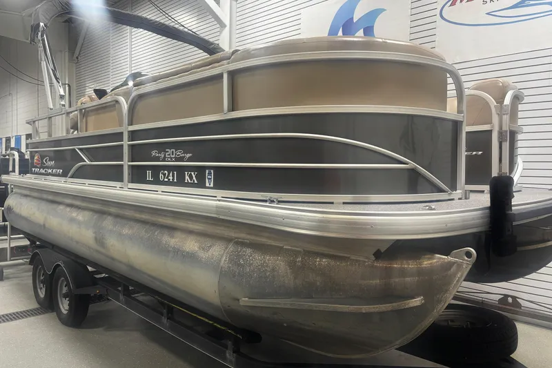 Slide: The Image of 2018 Sun Tracker Party Barge 20 DLX pontoon boat on trailer in showroom. - 18
